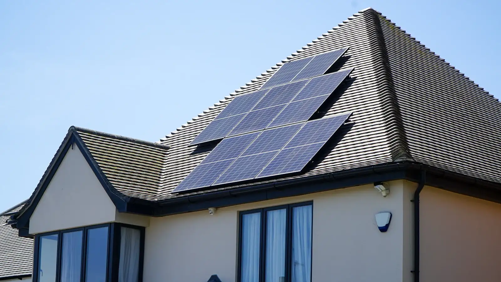 Solar panels on the tiled roof of a rendered house